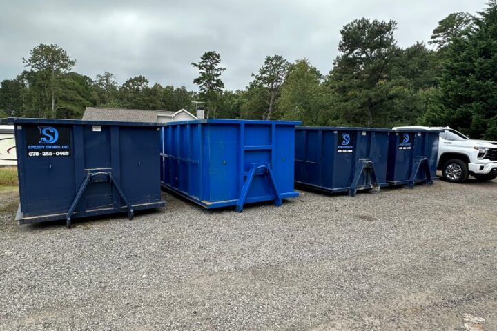 Dumpsters of Different Sizes Lined Up By The Side of a Road