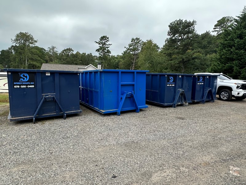 Dumpsters of Different Sizes Lined Up By The Side of a Road
